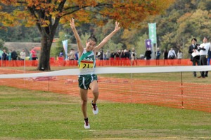 手を挙げ、1位でゴールする小千谷中学校男子駅伝チームの画像