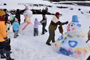 大崩雪まつりで雪だるまを作る参加者の画像