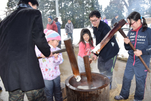 大崩地区雪まつりで餅つきをする参加者の画像