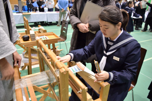 機織り体験をする中学生の画像