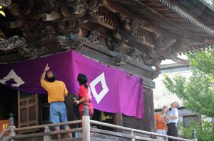 建物の周囲の彫刻を見る来場者の画像