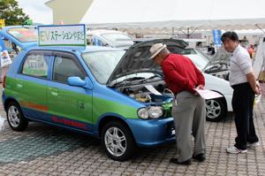 電気自動車の内部を見る来場者の画像