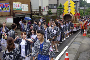 元気良く花火の筒を引く若者の画像