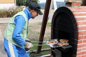 窯でピザを焼くスタッフの画像