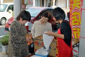 野菜の詰め放題をするお客さんの画像