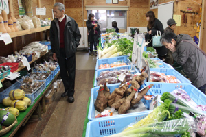 新鮮な野菜を選ぶ来場者の画像