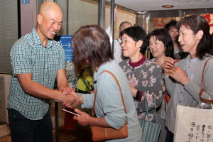 来場者と握手する田中陽希さんの画像