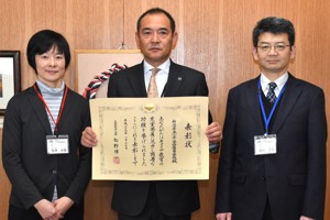 賞状を手にする小千谷西高等学校校長と教員の画像