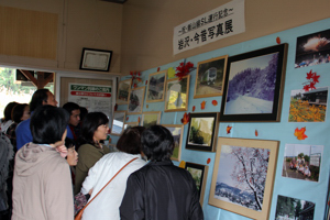 岩沢駅内に展示された写真展に見入るお客さんの画像