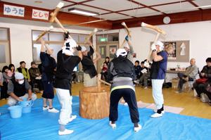 順番に杵を振りかざして餅をつく保存会のみなさんの画像