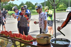 休憩所で地元の野菜を食べる参加者の画像