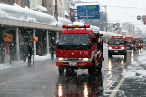 行進する消防車輌部隊の画像