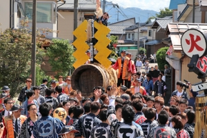 元気良く花火の筒を引く若者の画像