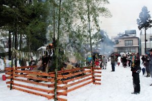 燃えるさいの神を見守る住民の画像