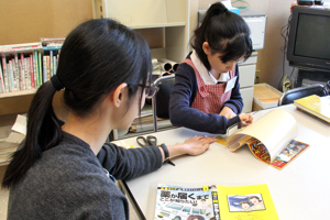 本にカバーを貼るこども図書館員の画像