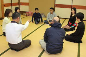 輪になって座っている参加者の画像