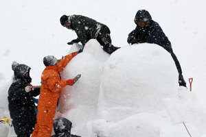 雪を固めて形を作る参加者の画像