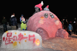 雪像に集まる子どもたちの画像