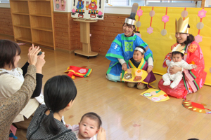 おひなさまと写真を撮る子どもたちの画像