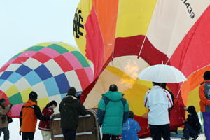 バーナーの炎で膨らむ熱気球の画像