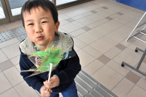 嬉しそうに風車を吹く男の子の画像