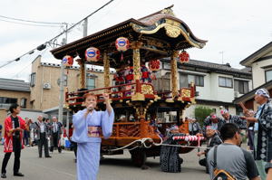 伝統祭り屋台の道中で歌や踊りが披露される画像