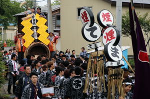 元気良く花火の筒を引く若者の画像