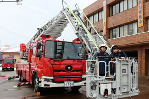 はしご車に乗る一日消防署長の画像