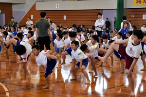 準備体操として四股を踏んでいる子どもたちの画像