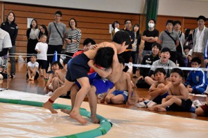 土俵際で取り組んでいる男子の画像