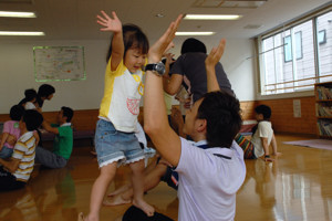 膝の上に立ち、バランスをとる子どもの画像