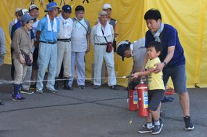 親子で初期消火の訓練を行っている画像