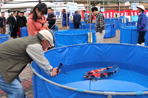 大きな錦鯉を撮影する来場者の画像