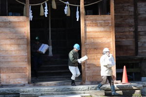 神社から貴重な資料に見立てた箱を搬出する参加者の画像