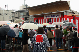 雨の中、ネギッコのショーを見る来場者の画像