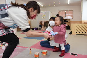 飾りを職員に手渡す子どもの画像