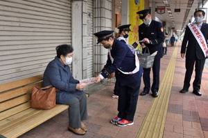 商店街で防火広報のチラシを配る児童の画像