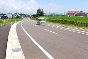 開通した道路を走る車の画像