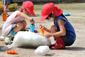 雪を触っている子どもたちの画像