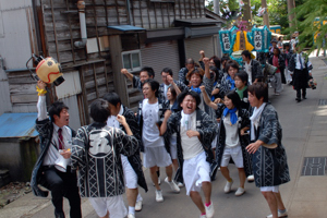 祭りの屋台を引いている若者の画像