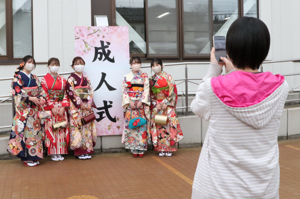 成人式で看板の前で記念撮影をしている4人の成人の画像