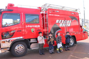 消防車両の前で記念撮影をする子どもの画像