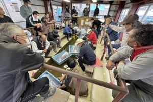 多くの人が集まった錦鯉の初競りの会場内の画像