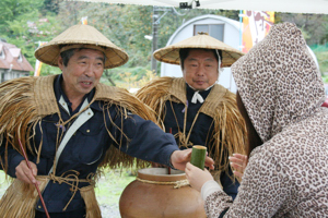 むじな焼酎をふるまう画像