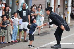 大道芸フェスティバルでパフォーマーと観客が握手をしている画像