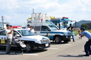 警察の特殊車両と記念撮影をする家族の画像