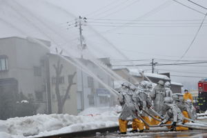 消防出初式で放水をしている消防団員の画像