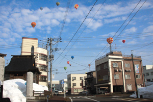 市街地の上空を飛ぶ熱気球の画像