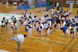 開会式後に準備体操として四股を踏む参加者の画像