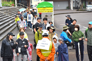 小千谷駅前を歩く参加者とクイズに挑戦する参加者の画像